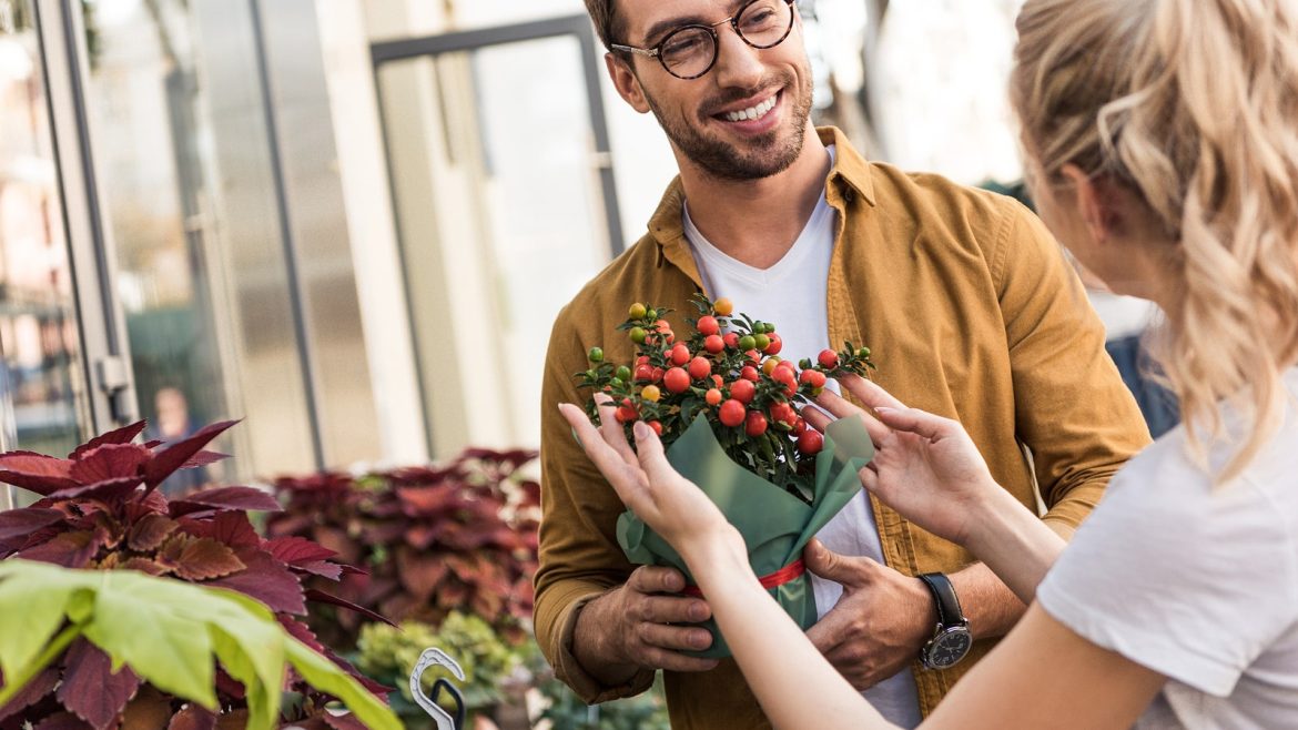 Smiling couple with flowers at a market, flowers theme