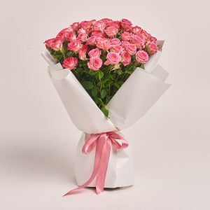 Bouquet of pink roses wrapped in white paper, flowers theme